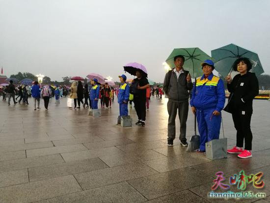 天安门广场游客自发为环卫工打伞