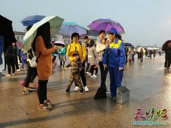 天安门广场下雨 游客自发为环卫工打伞(组图)