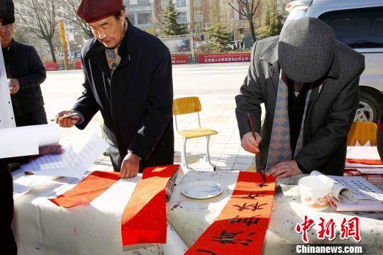 图为书法爱好者向民众书写春联。 张添福 摄
