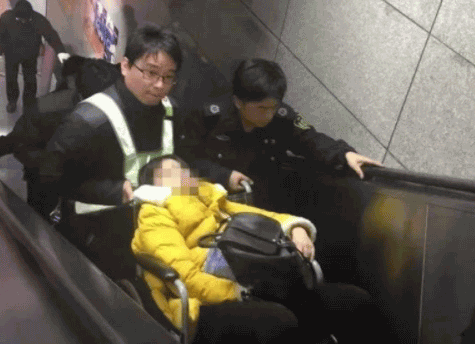用轮椅将女乘客推出地铁站