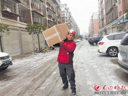 京东配送员蒋卫军正在冰雪路上送货。(长沙晚报记者 吴鑫矾 通讯员 常燕 摄影报道)