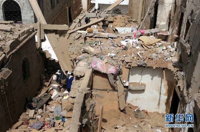 6月25日，在也门阿姆兰省，当地居民在废墟中寻找幸存者。