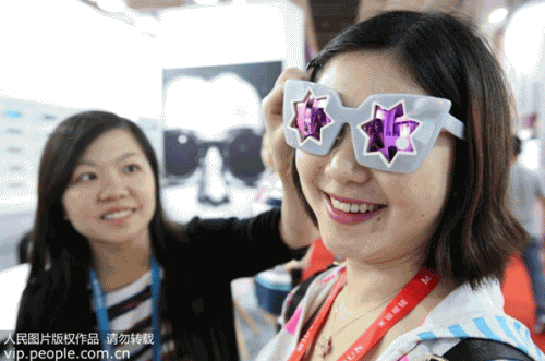 2015年9月9日，参观者在第二十八届中国国际眼镜业展会上试戴时尚太阳镜。（陈晓根/人民图片）