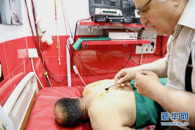 6月14日，中医针灸师萨巴赫在伊拉克首都巴格达的中医诊所为患者治疗。新华社发（哈利勒·达伍德摄）