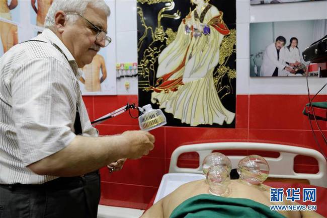 6月14日，中医针灸师萨巴赫在伊拉克首都巴格达的中医诊所为患者拔火罐。新华社发（哈利勒·达伍德摄）