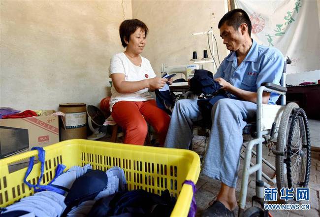7月3日，临西县西马鸣堂村贫困户孙秀霞和丈夫谭笑在家中加工帽子。