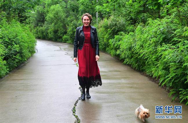 7月5日，在珲春市一处公园内，克里斯蒂娜陪伴宠物犬遛弯。