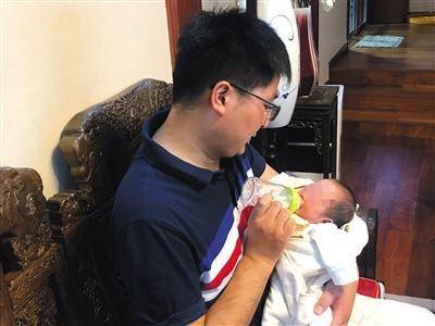 8月16日，王柯丁在家中给孩子喂奶。新京报记者 周小琪 摄