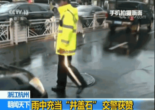 杭州交警雨中充当“井盖石” 确保过往车辆安全