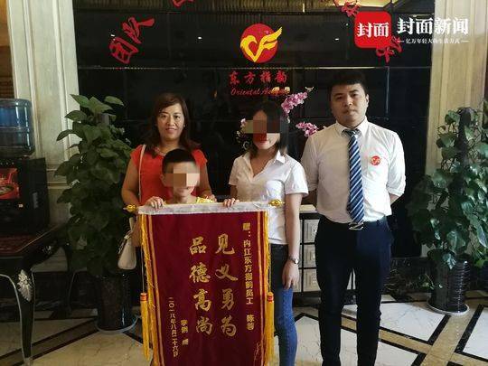 母子二人向陈皓月送锦旗致谢。