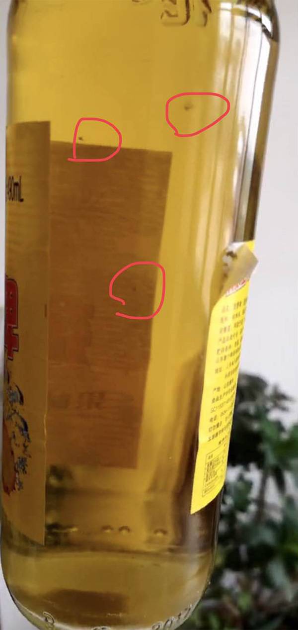 胡松提供的照片显示，菠萝啤瓶内出现杂质。胡松 供图