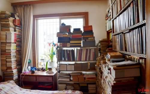  ↑刘国成家中卧室也满是藏书，床头柜书堆高过窗户上沿