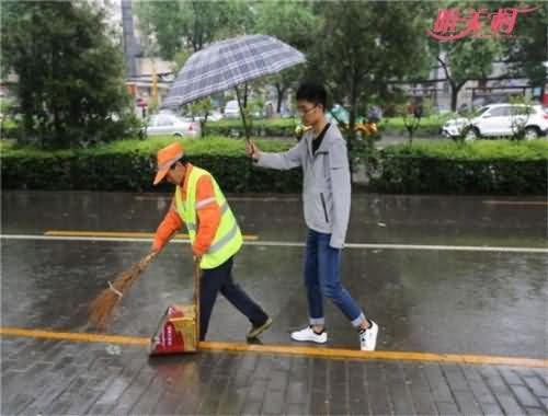 大学生为保洁撑伞 大学生为保洁撑伞
