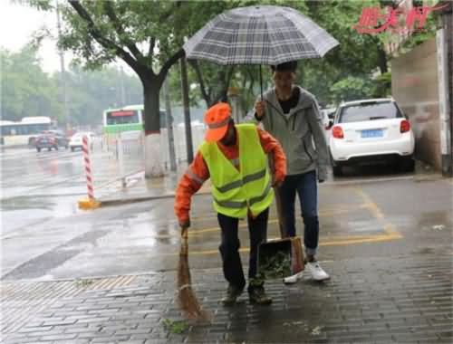 大学生为保洁撑伞 大学生为保洁撑伞
